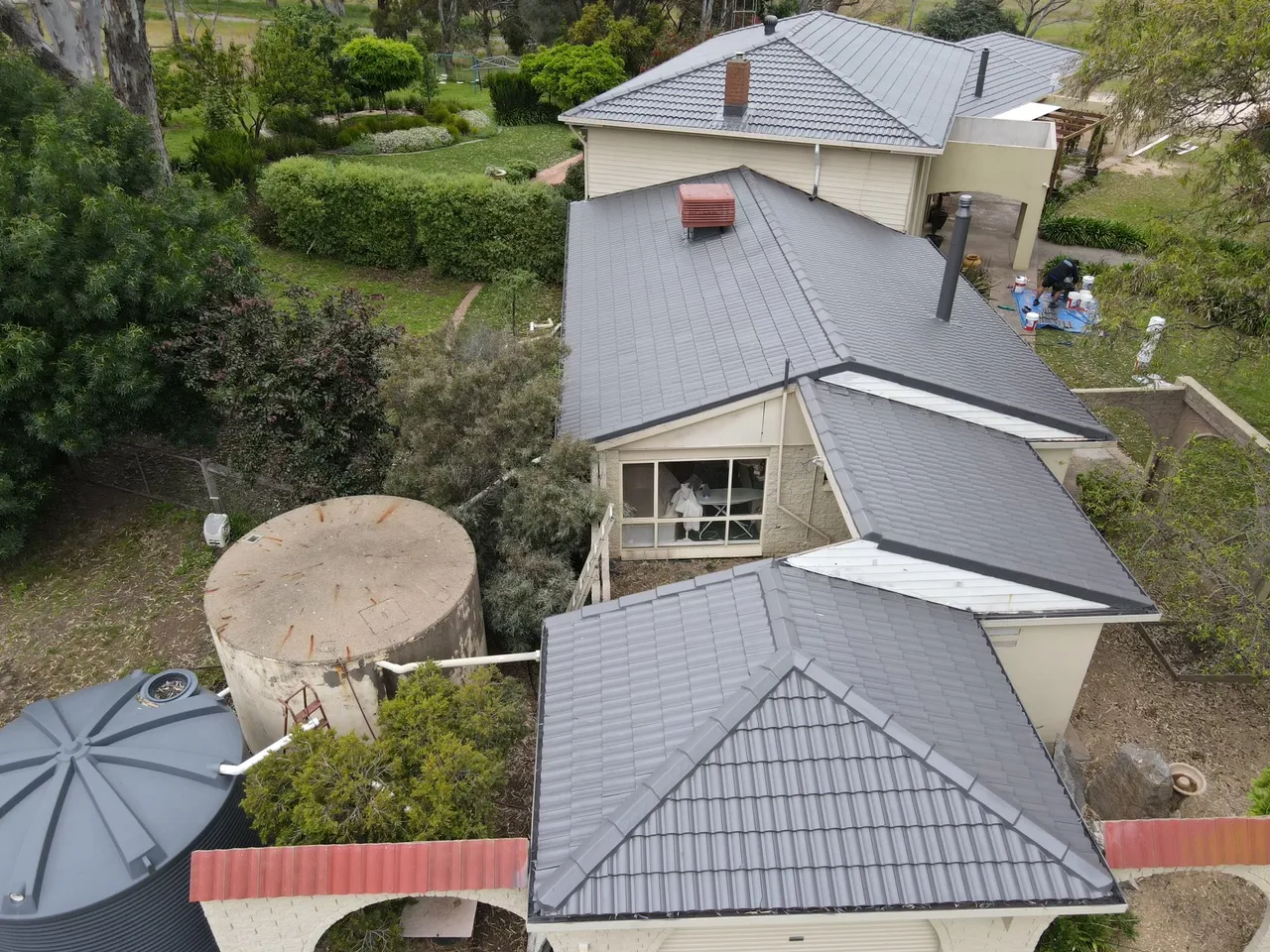 Rear hips and gables Several hipped tile roof sections restored in one colour, with the crew finishing up on the ground below, tile roof restoration by Roof Restoration Services Bendigo